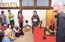 地域密着のガイドツアー「ＳＵＷＡエクスペリエンス」で、石埜三千穂さん（右）から仏像の説明を受ける参加者