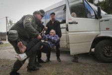 ウクライナ北東部ハルキウ州ボウチャンスク近郊の村で2024年5月11日、避難のために警察によって車に乗せられる住民=AP
