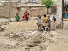 アフガニスタン北部バグラン州で2024年5月11日、大雨による水害を受けた町の様子を見る子どもたち＝ロイター
