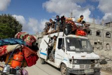 パレスチナ自治区ガザ最南部のラファで2024年5月12日、車に荷物を載せて避難する人たち=ロイター
