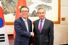 握手する韓国の趙兌烈（チョテヨル）外相（左）と中国の王毅（ワンイー）共産党政治局員兼外相=2024年5月13日、韓国外交省提供