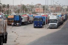 2024年4月25日、パレスチナ自治区ガザとの境界に位置するラファ検問所のエジプト側に並ぶトラックの列=ロイター