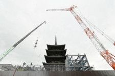 大型クレーンで運び入れられ、五重塔の周りに組み立てられる素屋根の鉄骨柱=2024年5月16日午前9時44分、奈良市、白井伸洋撮影