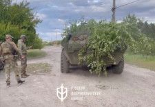 ウクライナ北東部ハルキウ州ボウチャンスクで、装甲車両の横に立つ「ロシア義勇軍団」の戦闘員。2024年5月13日に投稿された動画から=ロイター。「ロシア義勇軍団」は、ウクライナ側に立って戦うロシア人組織