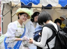 鹿鳴館をイメージした衣装でアイスを手渡すスタッフ=2024年5月9日、横浜市中区、中嶋周平撮影