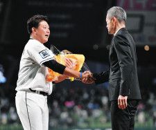 イチローさん（右）からサプライズの花束を受け取る松坂大輔さん＝2021年12月