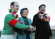シンボリクリスエスで有馬記念を連覇し、和田孝弘オーナー（右）と母親の洋子さん（中央）と握手をするペリエ＝2003年12月28日
