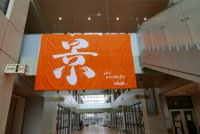 堀川高校の校舎に入ると、「景」の文字を染め抜いたオレンジ色の旗が掲げられている（撮影／編集部・福井しほ）