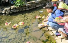 旧湯川家屋敷庭園から雛を流す子どもたち
