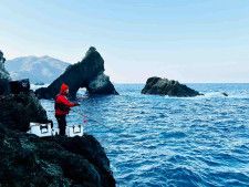 杉崎さんは船着け場に釣り座を構えた。奥に見えるのが「メガネ岩」。　©釣りビジョン