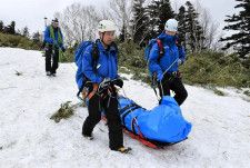 利尻山での訓練で負傷者役を担架で運ぶ道警山岳救助隊の隊員ら