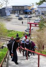 急な階段を上って鵜苫神社に向かう避難訓練の参加者たち
