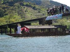 屋形船で結婚式を挙げ、橋の上からの花吹雪を受ける新郎新婦＝１０日、高知県四万十市