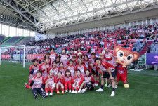 ゴール裏に集ったサポーターや子どもたちとともに記念撮影を行うINAC神戸の選手・スタッフ（写真提供：WEリーグ）