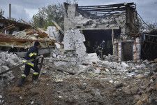 ロシアの空襲を受けた建物で消火活動をする消防隊員＝10日、ウクライナ南部ザポロジエ州（AP＝共同）