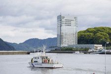 G7広島サミット主会場のグランドプリンスホテル広島（奥）周辺を警戒する海上保安庁の巡視艇＝19日午後、広島市