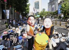 福島第1原発の処理水海洋放出に反対する集会で、日韓両首脳を批判するパフォーマンスをする人たち＝20日、ソウル（共同）