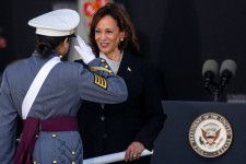 27日、米ニューヨーク州ウエストポイントの陸軍士官学校の卒業式で証書を渡すハリス副大統領（右）（ロイター＝共同）