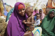 ソマリアの首都モガディシオ郊外で、栄養失調の子どもを抱く母親＝2022年6月（AP＝共同）