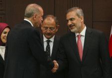 トルコ外相に任命されたフィダン氏（右）と握手するエルドアン大統領（左）＝3日、アンカラ（AP＝共同）