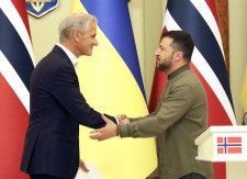 24日、ウクライナ・キーウでの共同記者会見で握手するゼレンスキー大統領（右）とノルウェーのストーレ首相（共同）