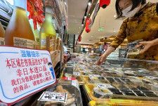 北京市内のスーパーのすし売り場。「日本から輸入したものではありません」との説明（左）が掲示されていた＝29日（共同）