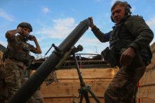 4日、ウクライナ南部ザポロジエ州で、ロシア軍に向けて迫撃砲を発射するウクライナ兵（ロイター＝共同）