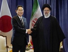 イランのライシ大統領（右）と握手する岸田首相＝20日、米ニューヨーク（共同）
