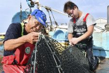 底引き網漁師の鈴木三則さん（左）＝20日、福島県いわき市