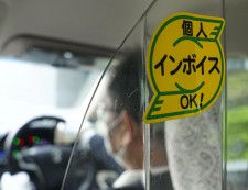 インボイス制度の開始に備え、個人タクシーの車内に貼られたステッカー＝30日午後、大阪市