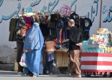 全身を覆うブルカ姿で買い物する女性＝4日、アフガニスタン・カブール（共同）
