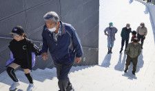 徒歩で移動する訓練参加者ら＝5日午前、徳島県鳴門市の道の駅「くるくるなると」