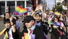 福岡市で開かれた「レインボーパレード」で虹色の旗を振りながら市街地を歩く人たち＝5日午後