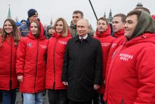 モスクワの「赤の広場」でボランティアらと記念撮影に応じるロシアのプーチン大統領＝4日（タス＝共同）