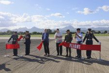 6日、フィリピン北部フロリダブランカのバサ空軍基地で、アスファルト舗装の更新を終えた滑走路に立つテオドロ国防相（右から4人目）や米当局者ら（共同）