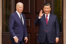バイデン米大統領（左）と並び、手を振る中国の習近平国家主席＝15日、米カリフォルニア州ウッドサイド（ロイター＝共同）