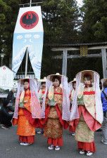 「八咫の火祭り」で竹灯籠を手に練り歩く平安装束の女性ら＝26日午後、和歌山県田辺市