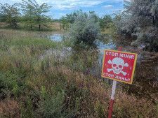 ウクライナ南部ヘルソン州で、地雷原の存在を知らせる看板＝6月（ロイター＝共同）