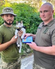 ウクライナ軍に貢献したとして賞を授けられたネコと、飼い主のオレクサンドル・リャシュクさん（左）＝9月、ウクライナ南部（リャシュクさん提供・共同）