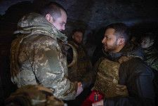 ウクライナ南部ザポロジエ州を訪問し、兵士と握手するゼレンスキー大統領（右）＝4日（ウクライナ大統領府提供、AP＝共同）