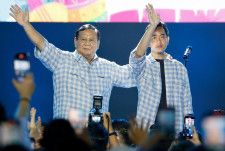インドネシア大統領選で勝利を確実にし、支援者に手を振るプラボウォ国防相（左）とギブラン氏＝14日、ジャカルタ（ロイター＝共同）
