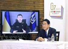 G7首脳テレビ会議に出席した岸田首相。画面はウクライナのゼレンスキー大統領＝2023年2月24日夜、首相公邸（内閣広報室提供）