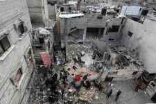 イスラエル軍の攻撃で破壊された建物近くに集まる住民＝16日、パレスチナ自治区ガザ南部ラファ（ゲッティ＝共同）