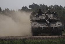 パレスチナ自治区ガザで、戦車に乗ったイスラエル軍兵士＝1月23日（AP＝共同）