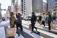 東京・銀座で買い物袋を手に歩く外国人ら＝1月