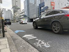 道交法で定める「自転車は車道左側通行」を示す路面標示＝24日、大阪市