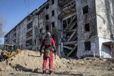 ウクライナ南部ヘルソンで爆発により損傷した建物を見つめる当局者＝9日（ゲッティ＝共同）