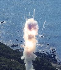 小型ロケット「カイロス」1号機が打ち上げ直後に爆発し、煙とともに飛び散る破片＝13日午前11時1分、和歌山県串本町（共同通信社ヘリから）