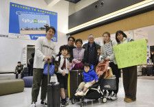 台湾から訪れた親戚を熊本空港の国際線到着口で迎え、写真に納まる家族＝2月5日、熊本県益城町