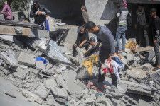 イスラエル軍の空爆後、自宅から物を取り出す人々＝20日、パレスチナ自治区ガザ南部ラファ（ゲッティ＝共同）